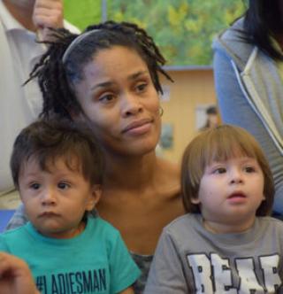 Diversity is key - two small boys sitting on woman's lap