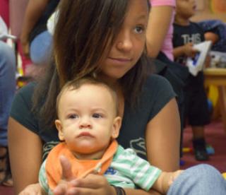 Young girl with small child in her arms 