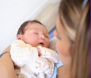 Mother cradles newborn