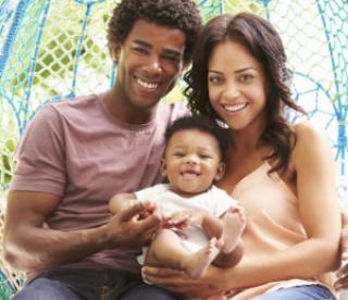 family with baby relaxing on outdoor garden swing seat 