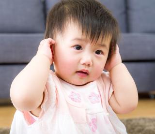 Disappointed little girl covering her ears isolated