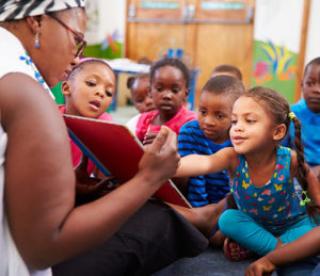 Teacher reading a book with a class of preschool children 