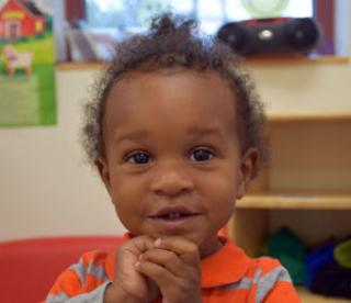 Smiling little girl with clenched hands 