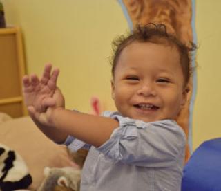 Happy baby grasping hands