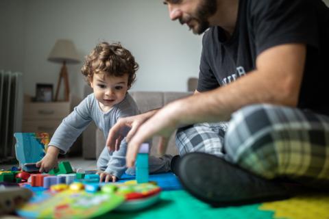 Dad and son playing on the floor. 