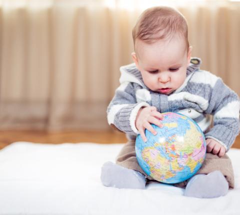 Baby explores a globe.