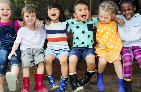 Our Team Diverse preschoolers happily sitting together.